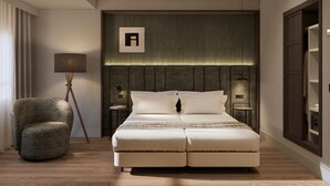 Una habitación de hotel moderna con una cama grande, una mesita de noche, una lámpara y una silla.