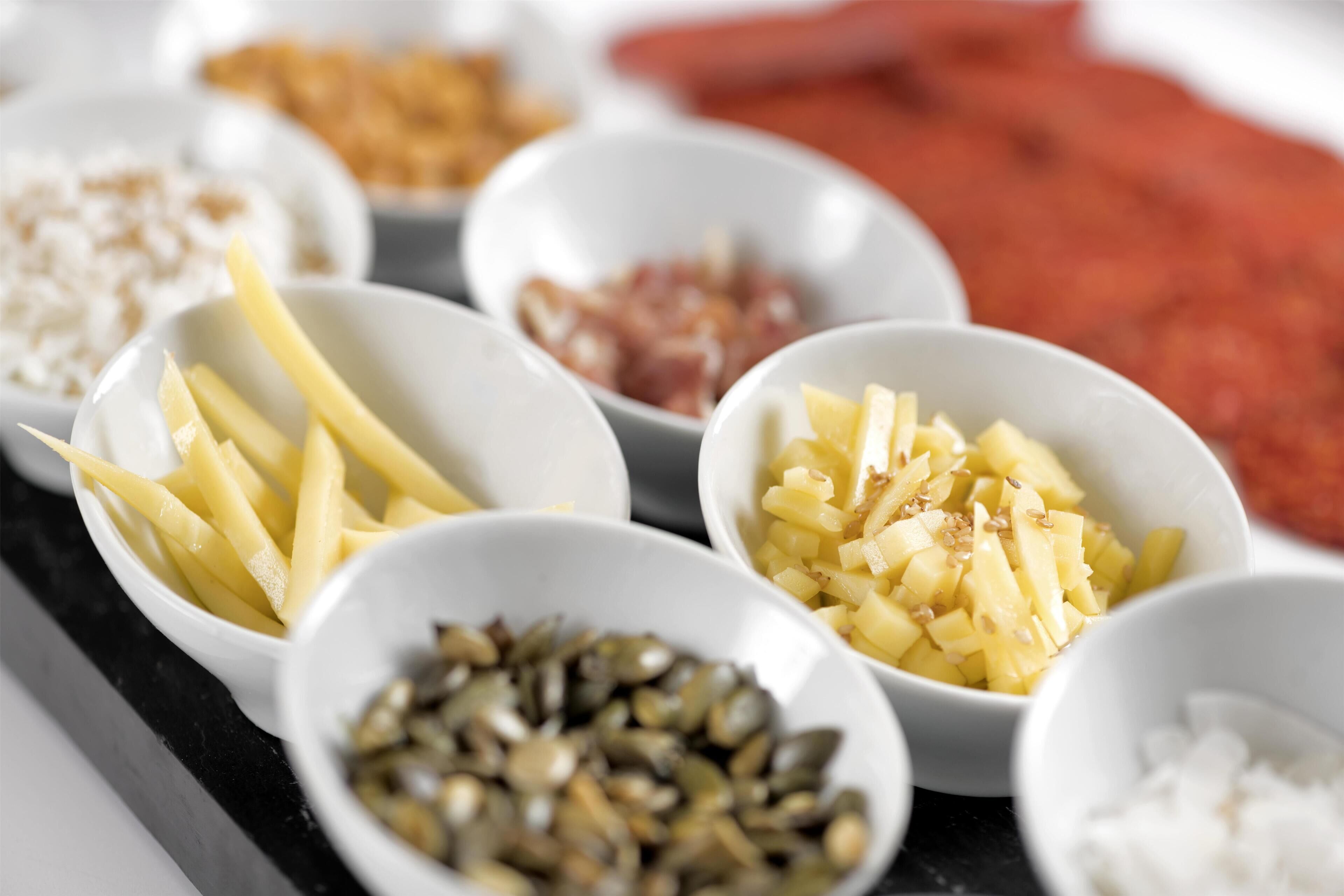 A variety of food items in bowls, including potatoes, nuts, and other ingredients.