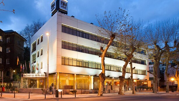 Un hotel moderno con estructura de dos pisos, ventanas amplias y una entrada destacada.