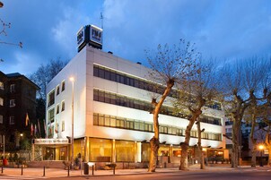 Un hotel moderno con estructura de dos pisos, ventanas amplias y una entrada destacada.