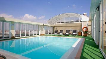 Een buitenzwembad en ligstoelen