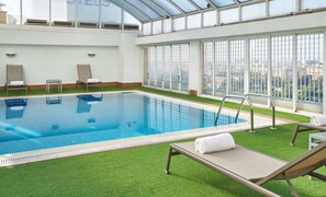 Una piscina al aire libre, sillones reclinables de piscina