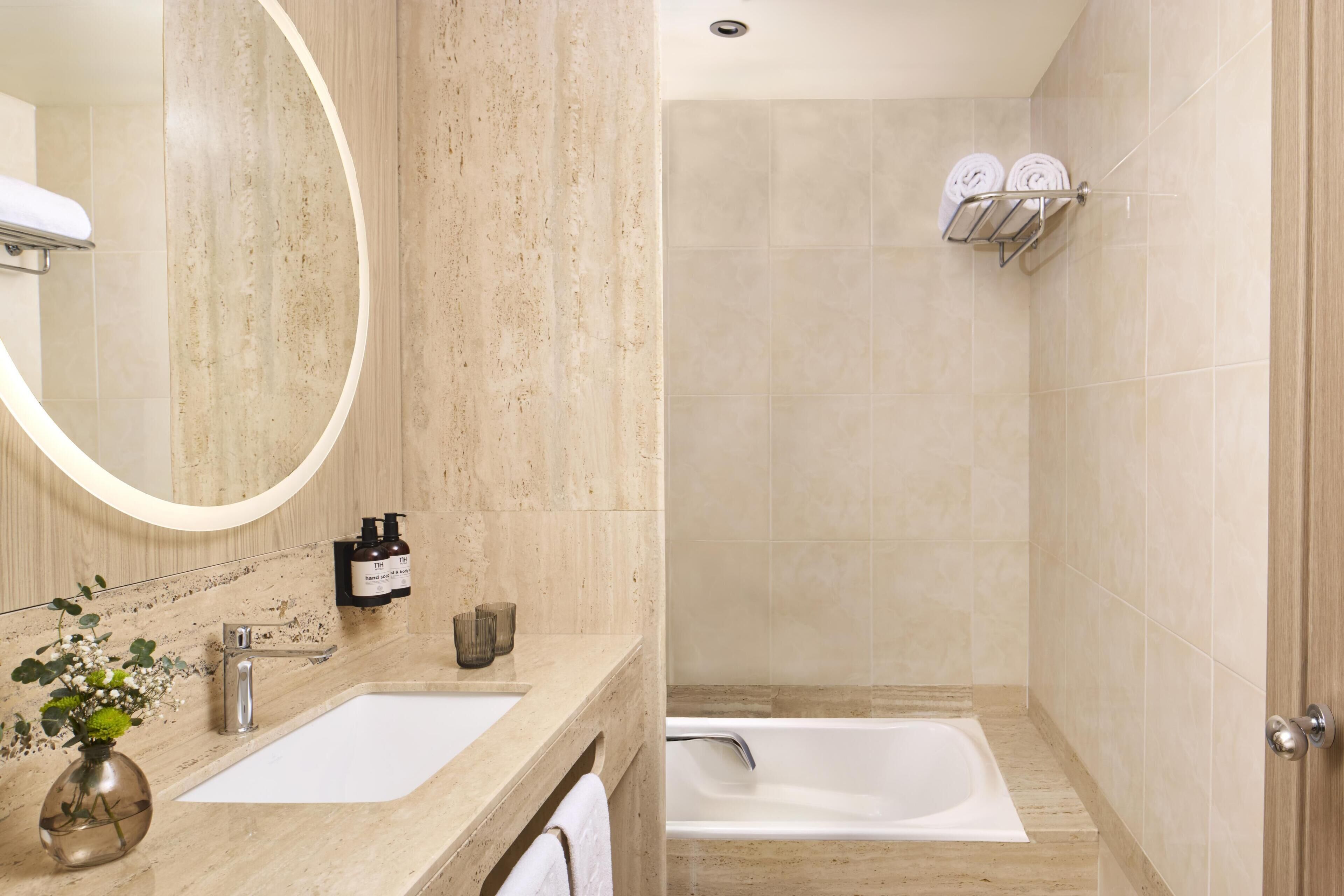 Un baño con lavabo, espejo y bañera.