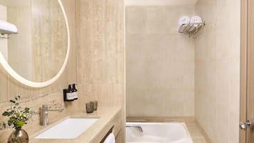 Un baño con lavabo, espejo y bañera.
