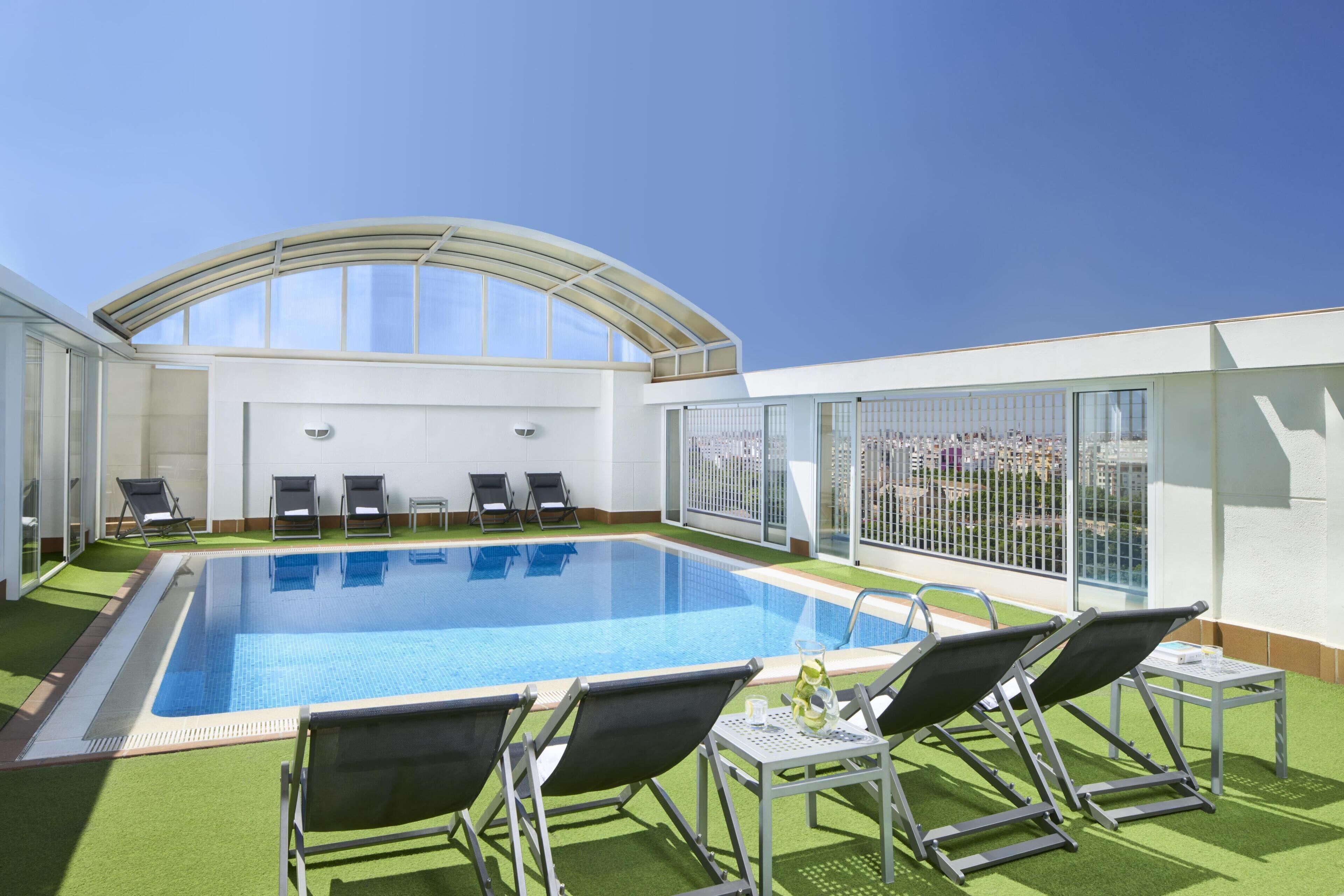 Una piscina al aire libre, tumbonas