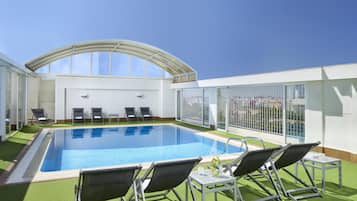 Una piscina al aire libre, tumbonas