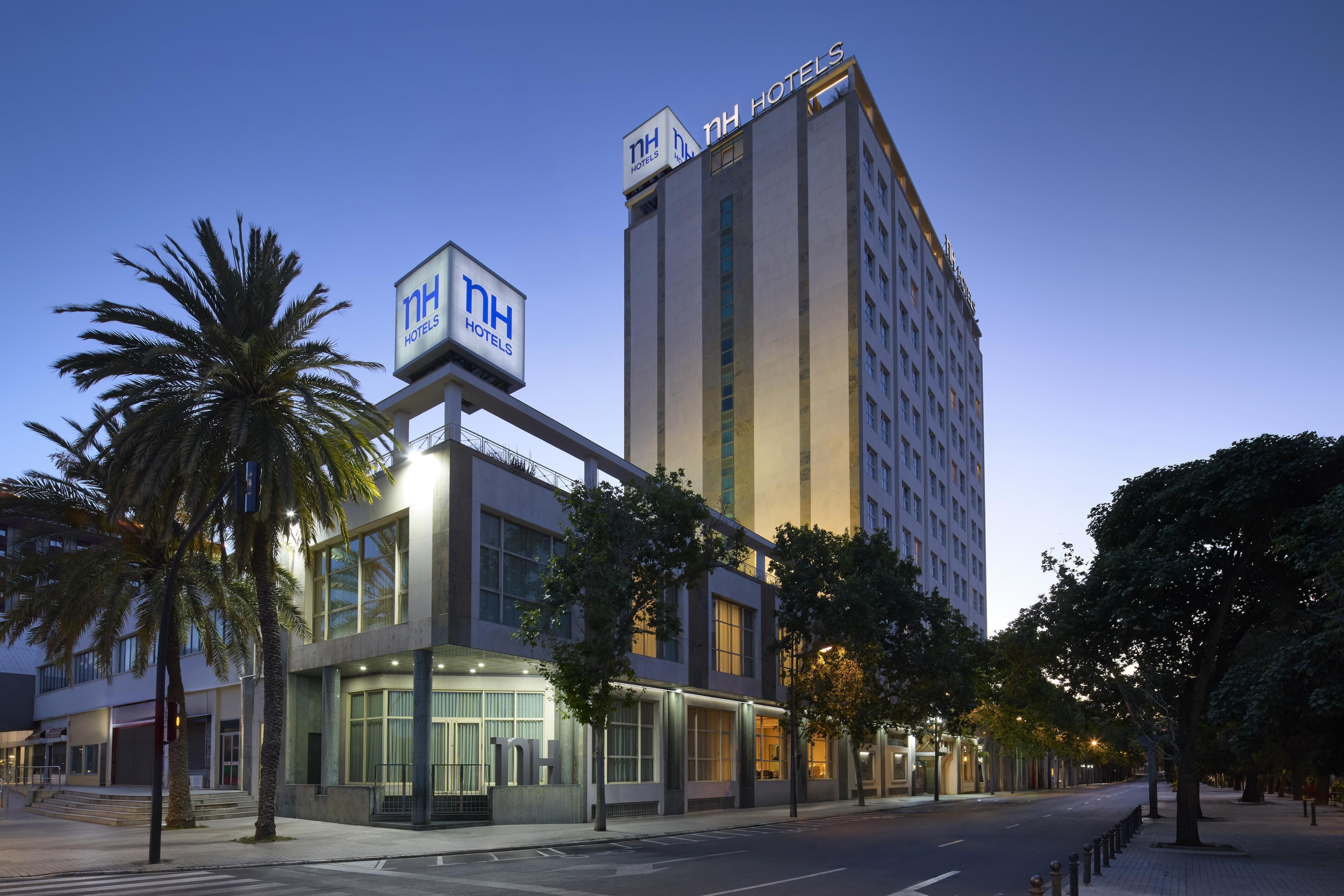 Un hotel con fachada moderna, amplias ventanas y señalización destacada.