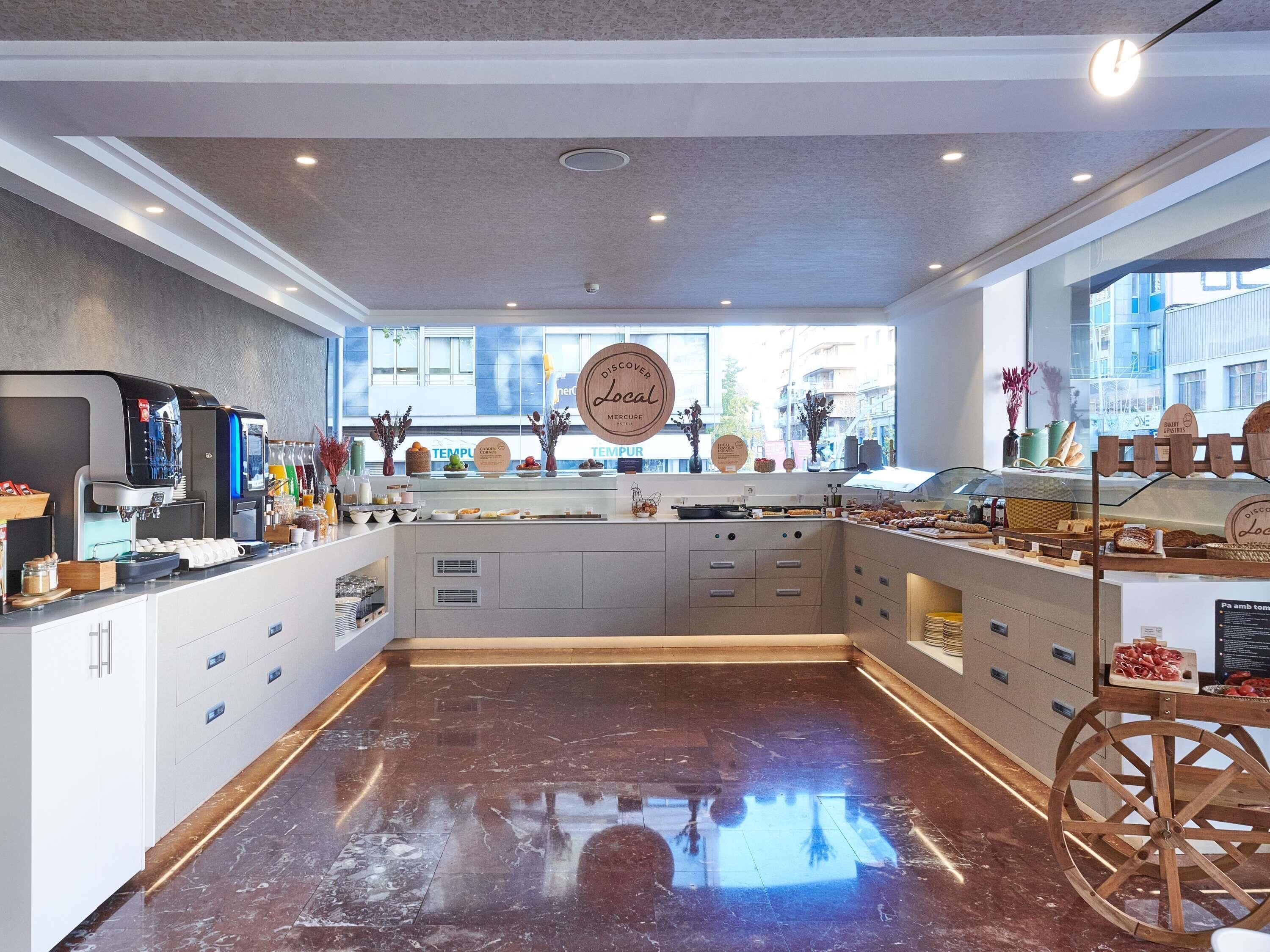 A modern cafe interior with a coffee machine, display case, and a large window.