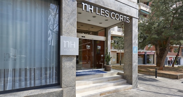 The exterior of NH Les Corts hotel with a clear entrance, steps leading up to the door, and a visible sign for the restaurant Rio del Barranco II. - NH Barcelona Les Corts (Barcelona)