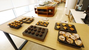 A buffet table with various pastries and desserts.