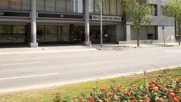 A modern building with multiple floors, large windows, and a sign that reads "NH CJIAT DE REUS".