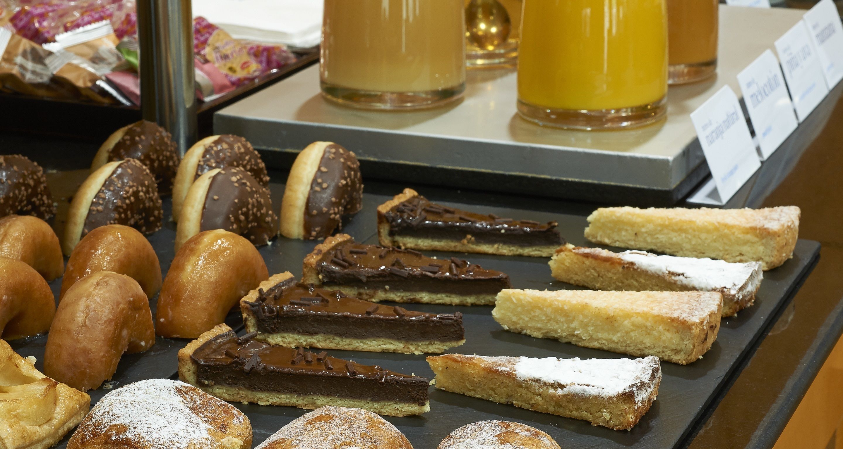 Una selección de pasteles y postres expuestos en mostrador.