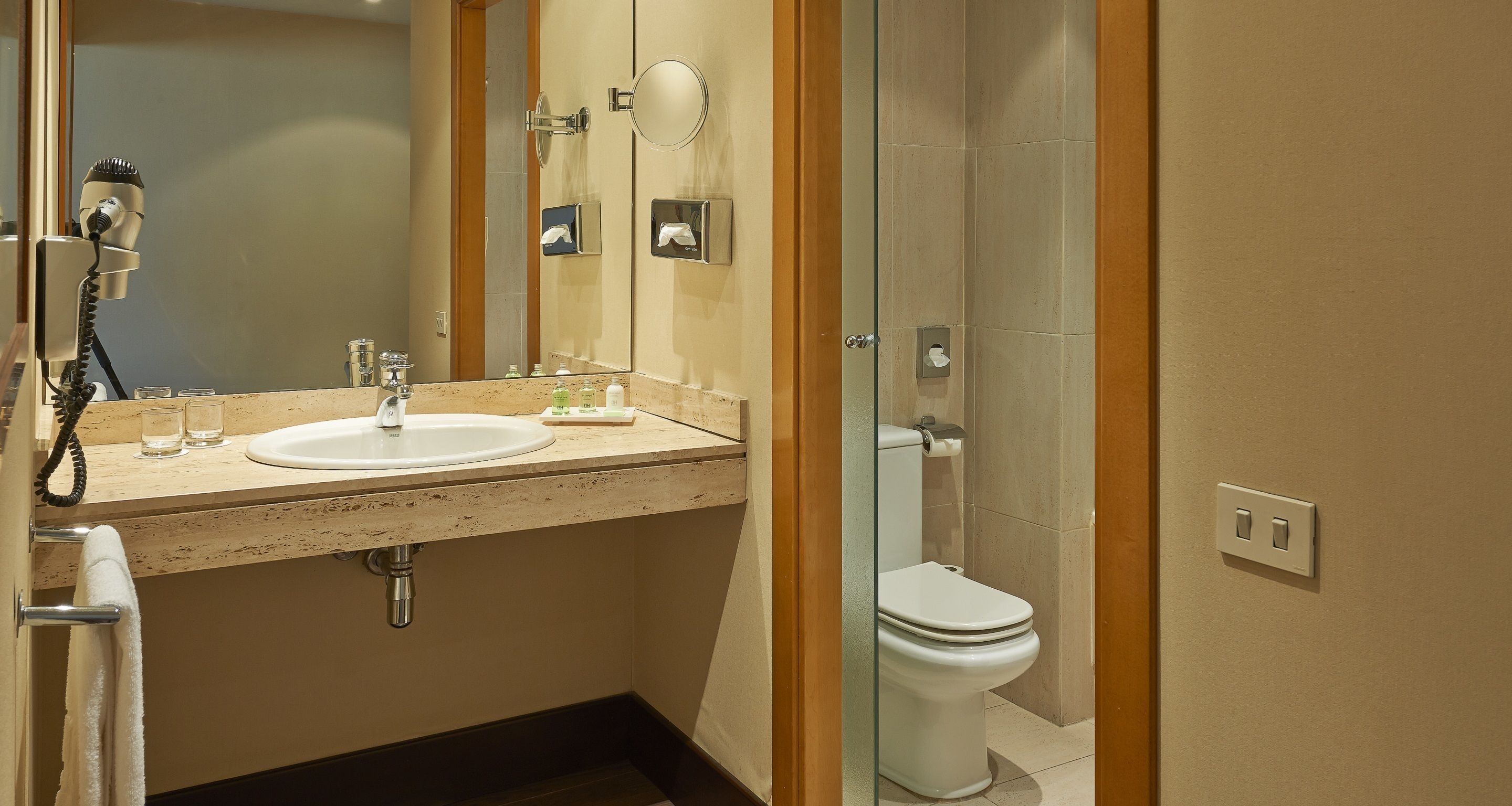 Un baño con lavabo, espejo e inodoro.