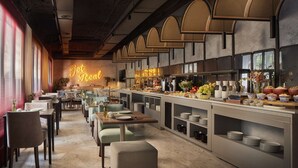 Un restaurante moderno con una barra larga, varias zonas de estar y un letrero de neón.