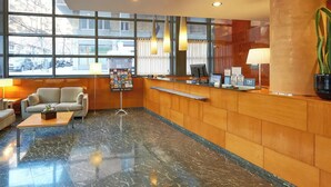 A hotel lobby with a reception desk, seating area, and large windows. - Bohemian Entenza (Barcelona)