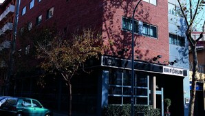 A red brick building with multiple windows and a sign for "MIFORUM" on the ground floor. - Bohemian Entenza (Barcelona)
