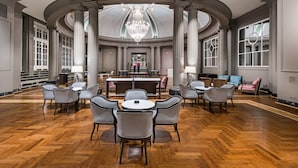 A spacious lobby with a central bar area, high ceilings, and a herringbone wood floor. - NH Collection Gran Hotel de Zaragoza (Zaragoza)