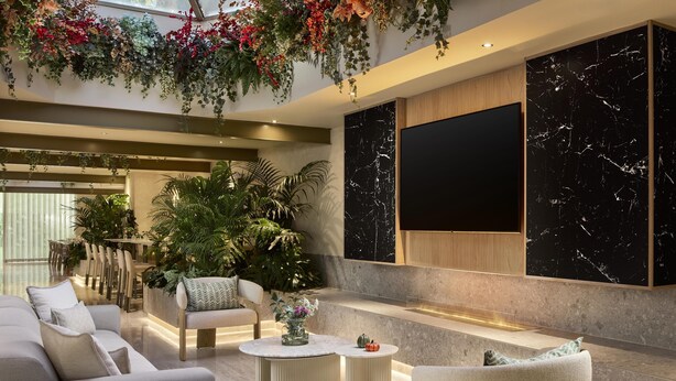Un interior moderno con un sofá, sillones, una mesa de centro y un comedor con sillas y una mesa.