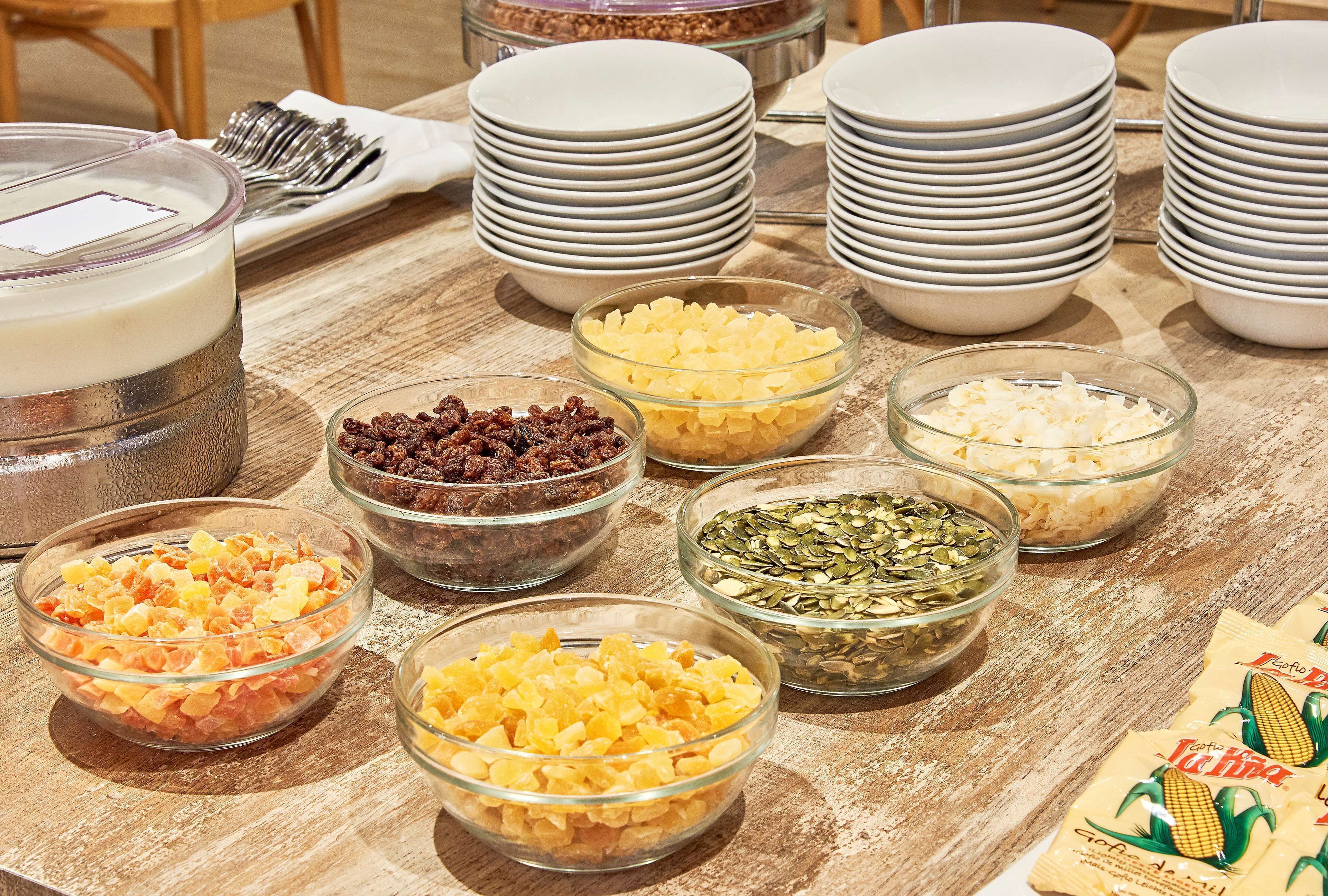 Una mesa de buffet con diversos alimentos y platos apilados.
