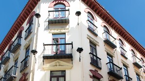Un hotel de estilo arquitectónico clásico, con varios balcones y una entrada destacada.