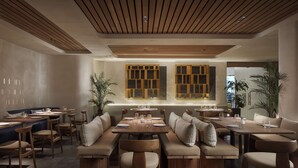 A modern restaurant with wooden furniture, a high ceiling, and large windows with wooden frames. - NH Madrid Lagasca (Madrid)