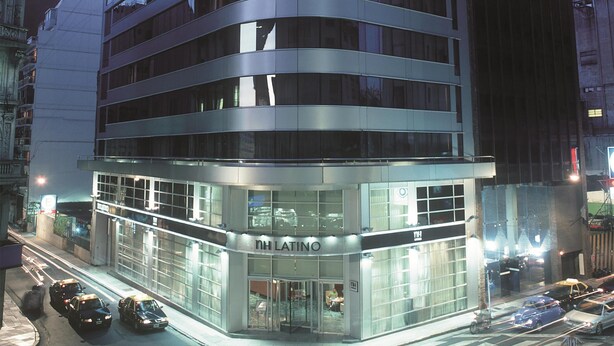 Un hôtel moderne à la façade incurvée, doté de grandes fenêtres et d’une enseigne bien visible sur le toit.