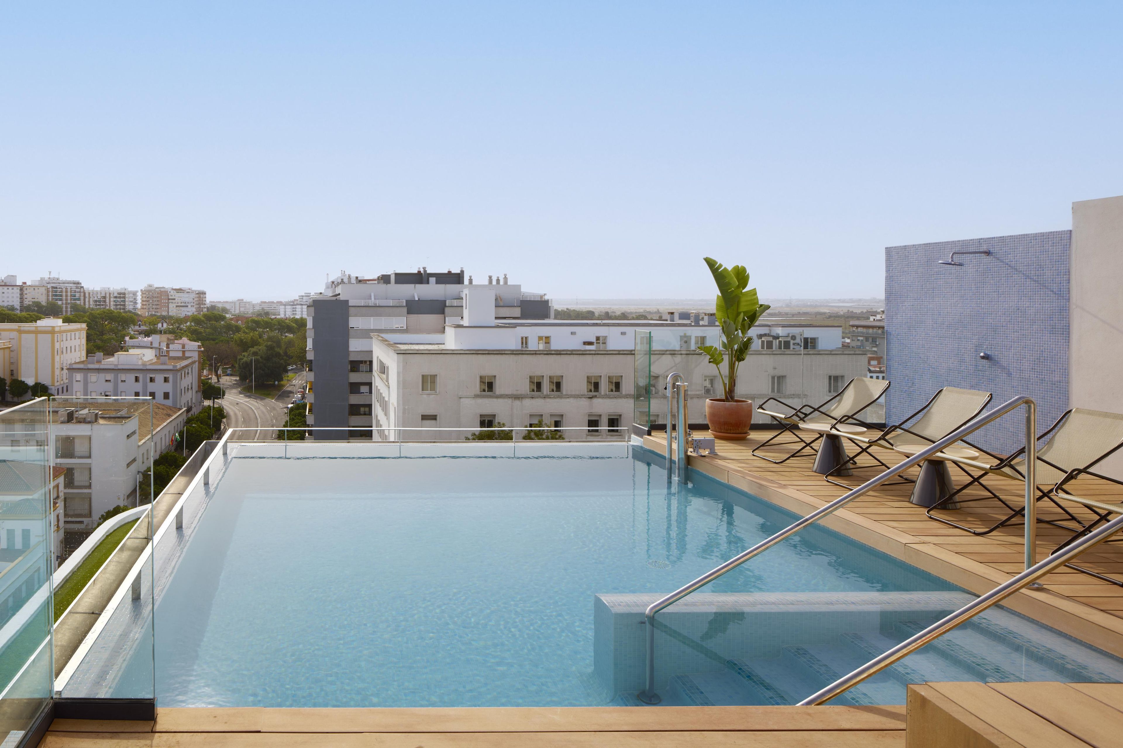 Una piscina infinita en la azotea con vistas despejadas del paisaje urbano.