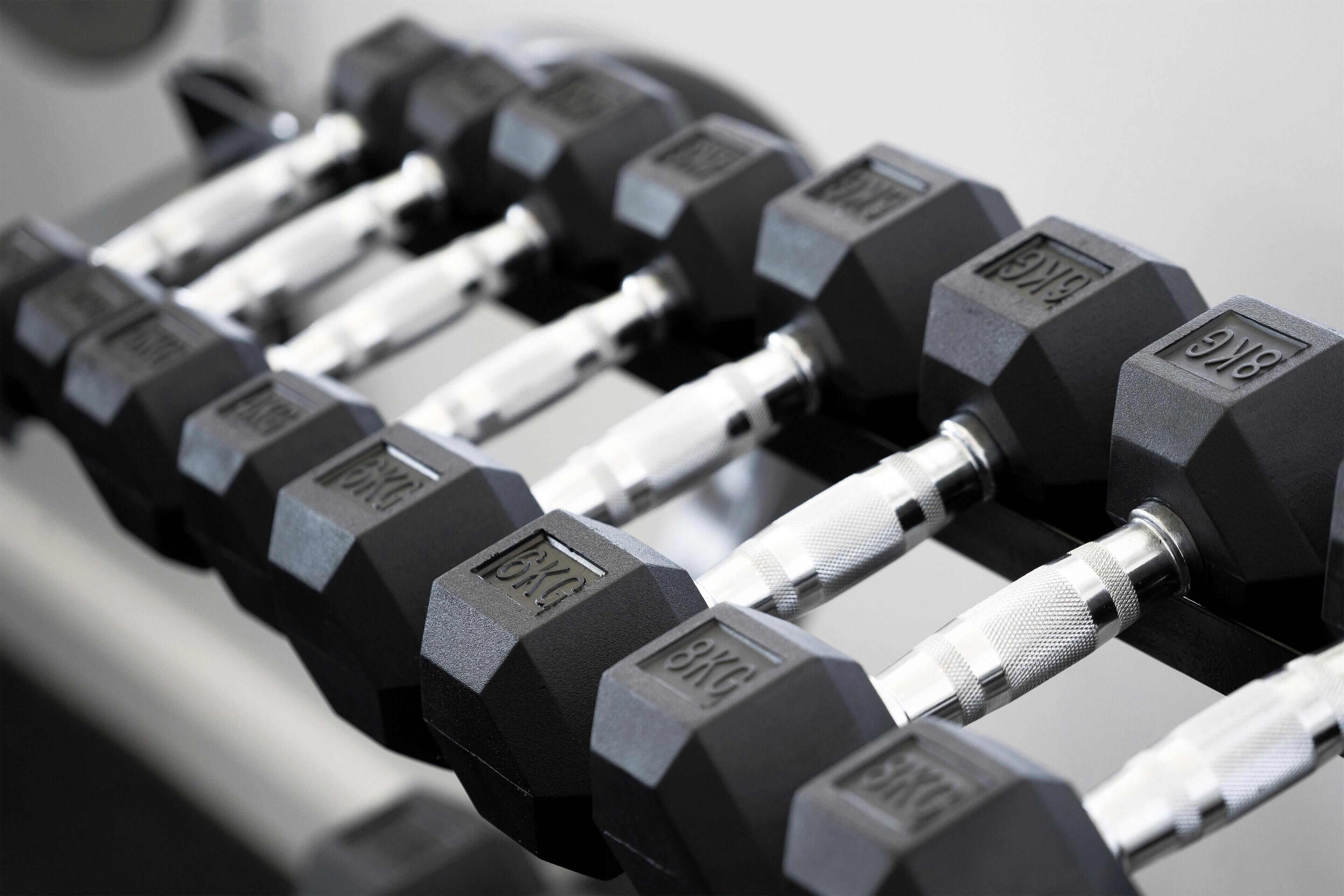 A set of black dumbbells with weight markings.