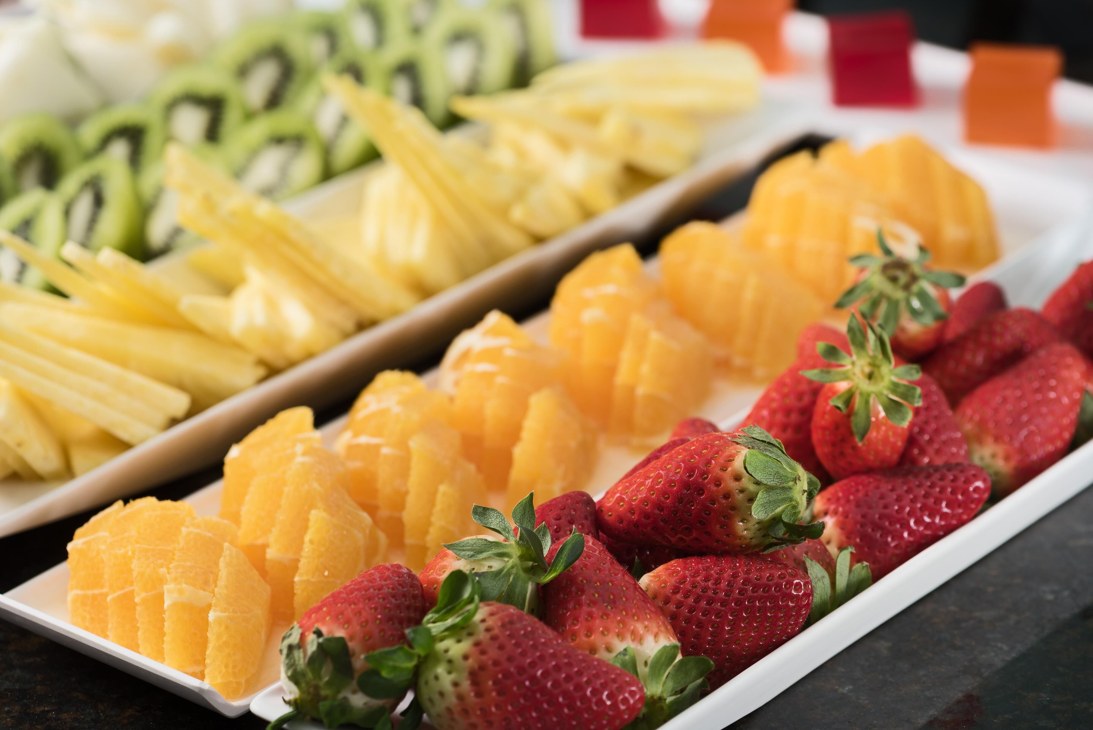 A fruit platter with sliced oranges, strawberries, and kiwi.
