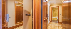 Een gang met houten deuren die leiden naar een badkamer met een bad.