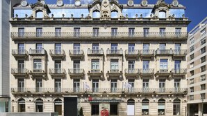 A multi-story building with ornate balconies and a central entrance.