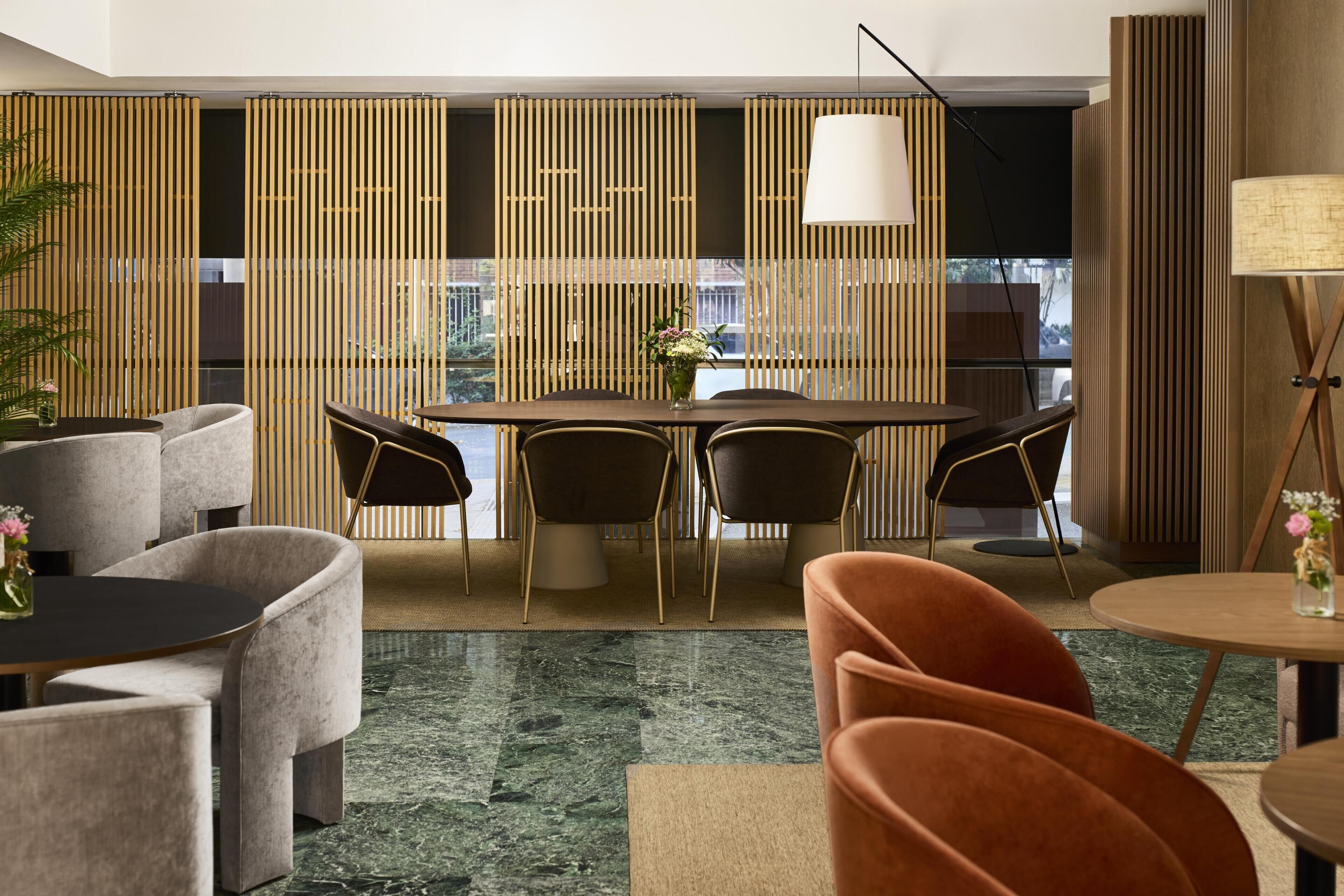 Un espace repas moderne avec une table ronde, des chaises et un vase décoratif.