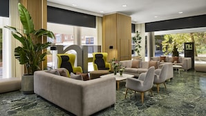 A modern hotel lobby with seating areas, large windows, and a marble floor. - NH Madrid Ventas (Madrid)