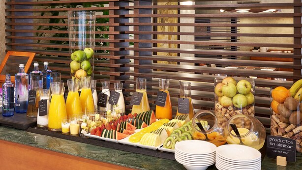 Un buffet de petit-déjeuner proposant une variété de fruits, de jus et de boissons en bouteille.