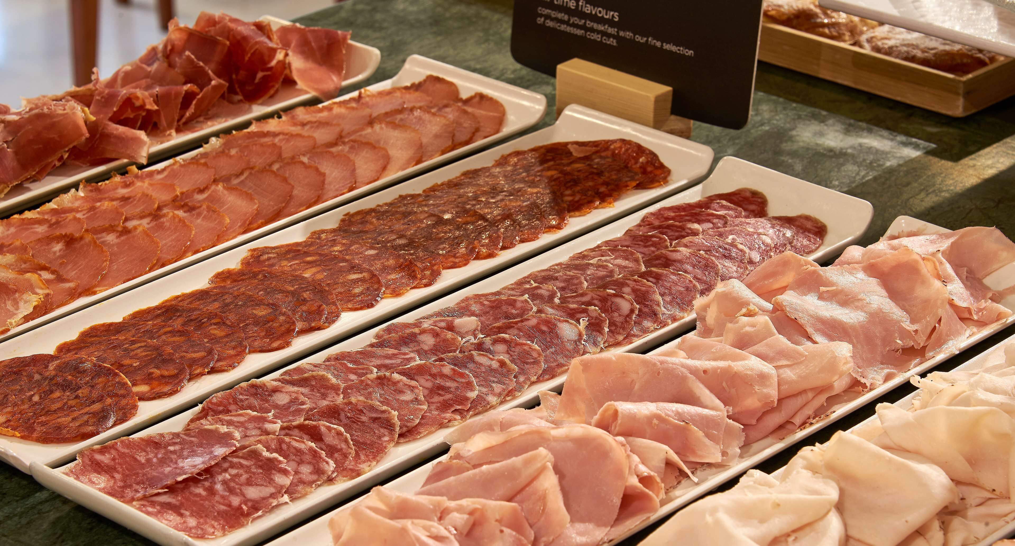 A variety of cured meats displayed on trays.