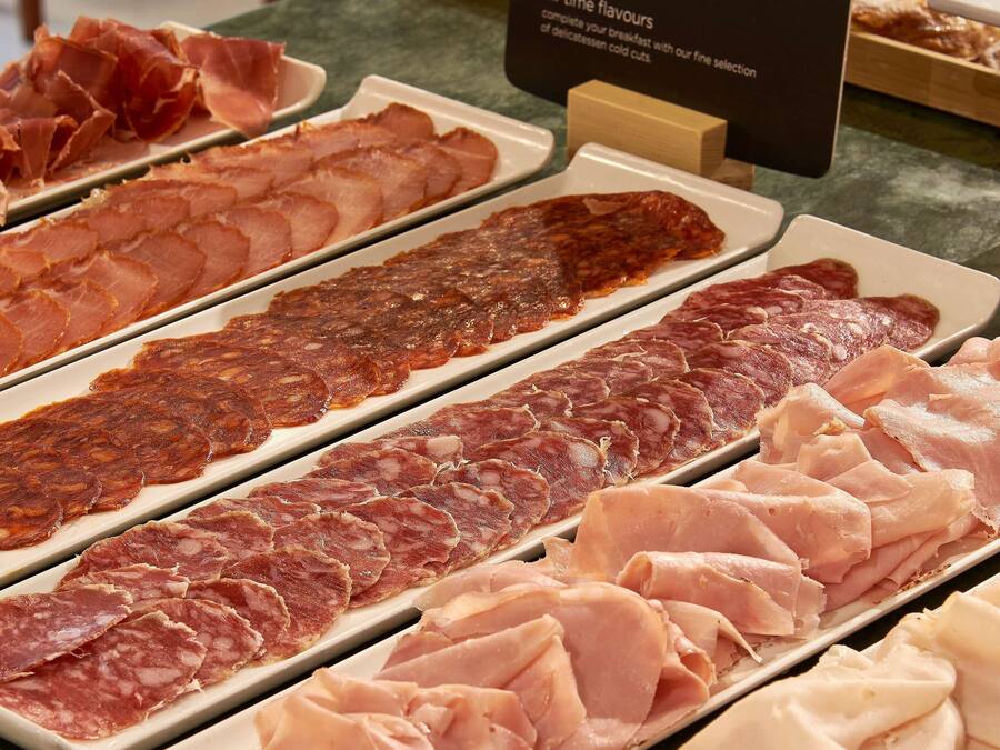 A variety of cured meats displayed on trays.