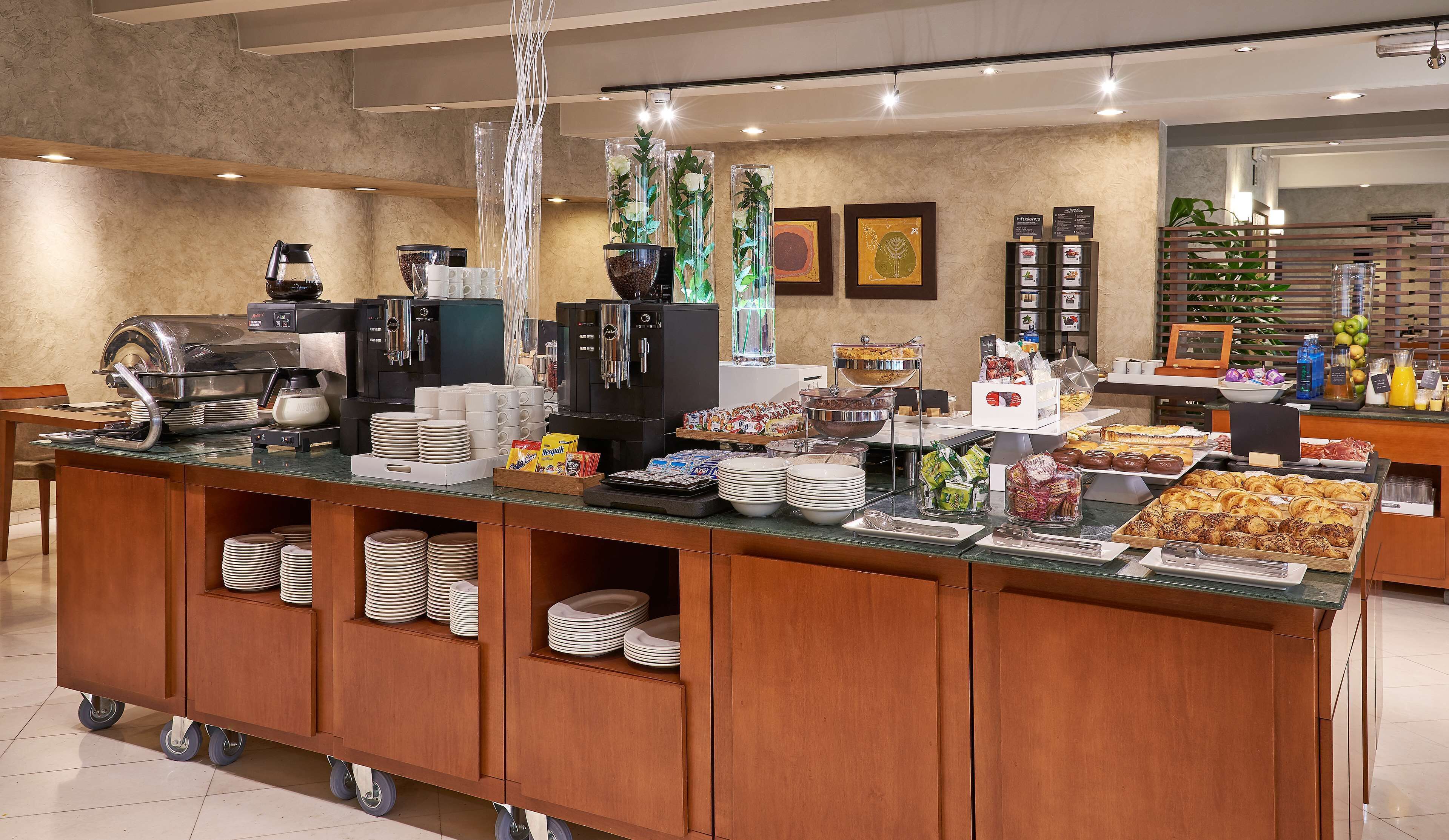 A buffet setup with various food items, coffee machines, and a coffee pot.