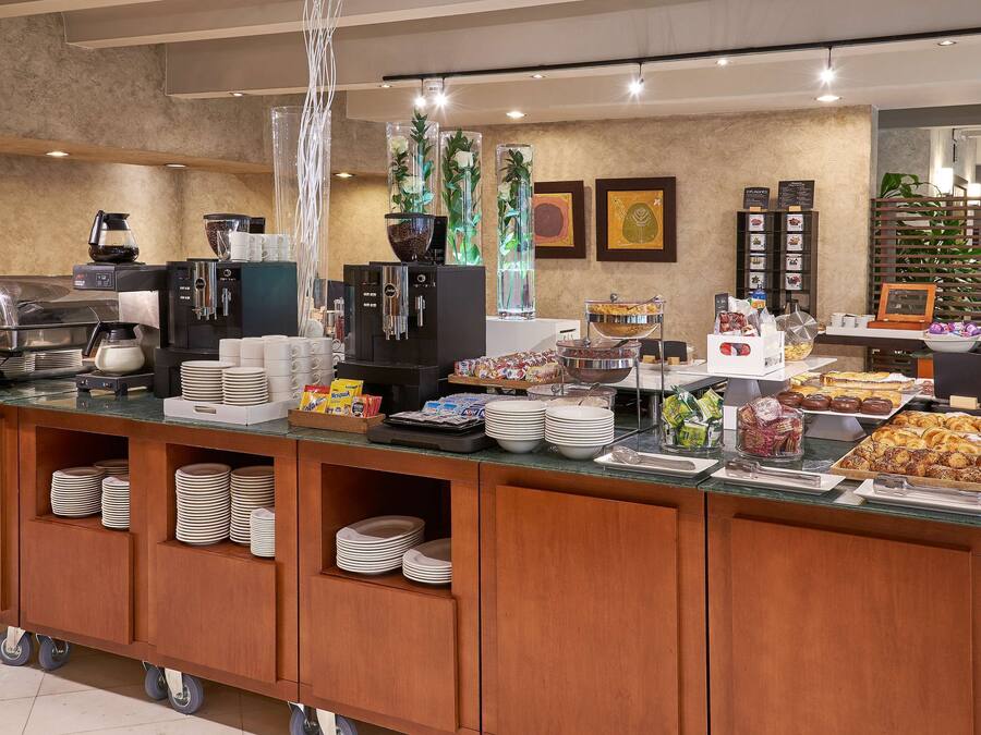 Un aparador de buffet amb diferents plats, màquines de cafè i una pota de cafè.