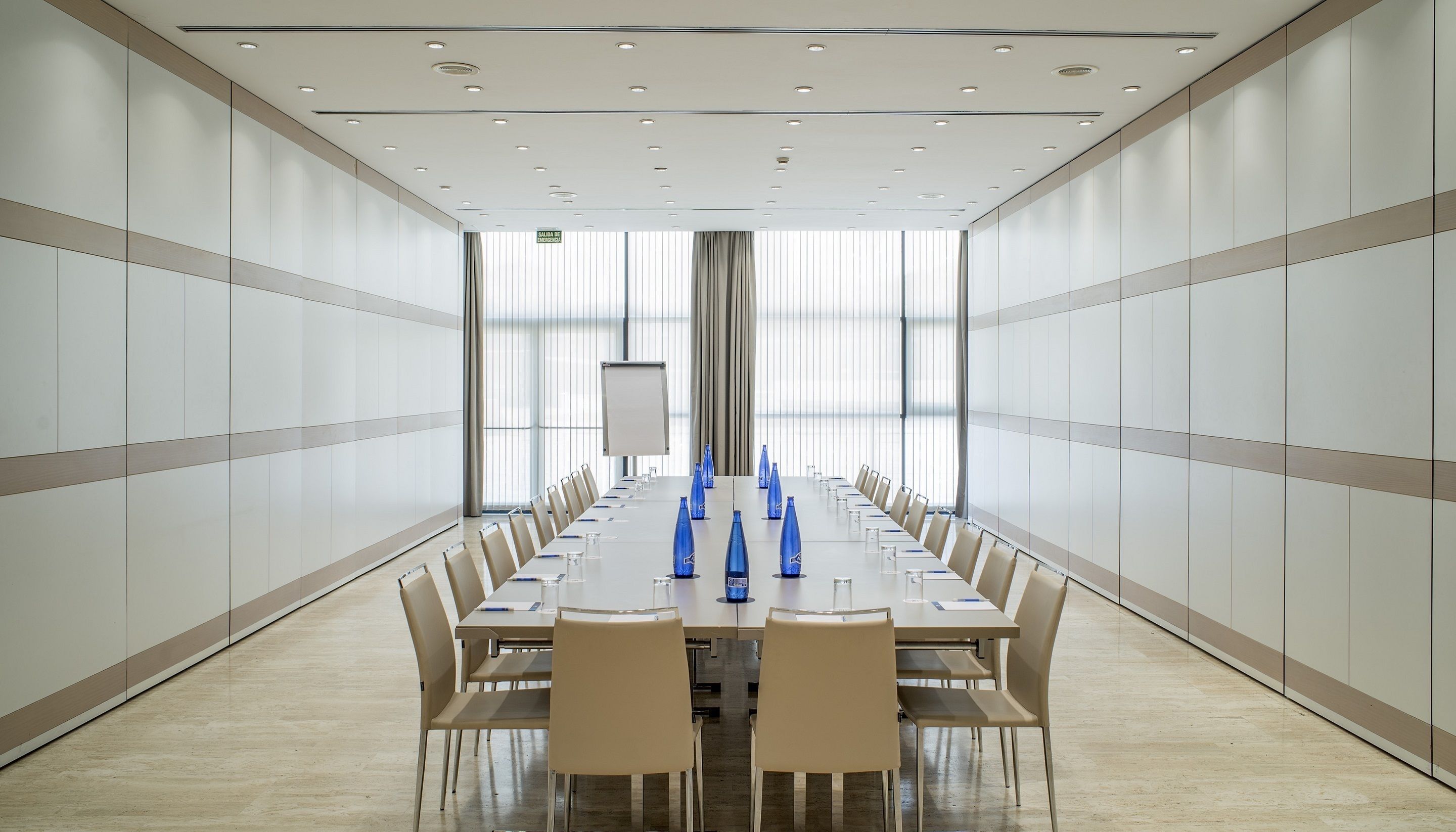 A conference room with a long table, chairs, and blue water bottles.