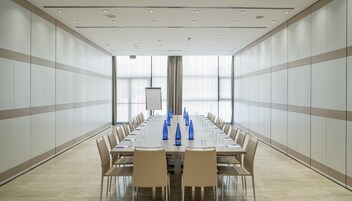 A conference room with a long table, chairs, and blue water bottles.