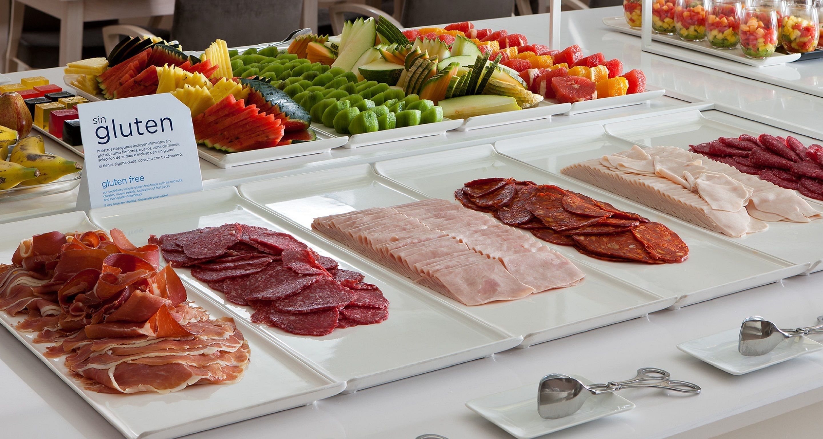 Un bufé con diversas opciones de comida, incluyendo carnes y frutas.