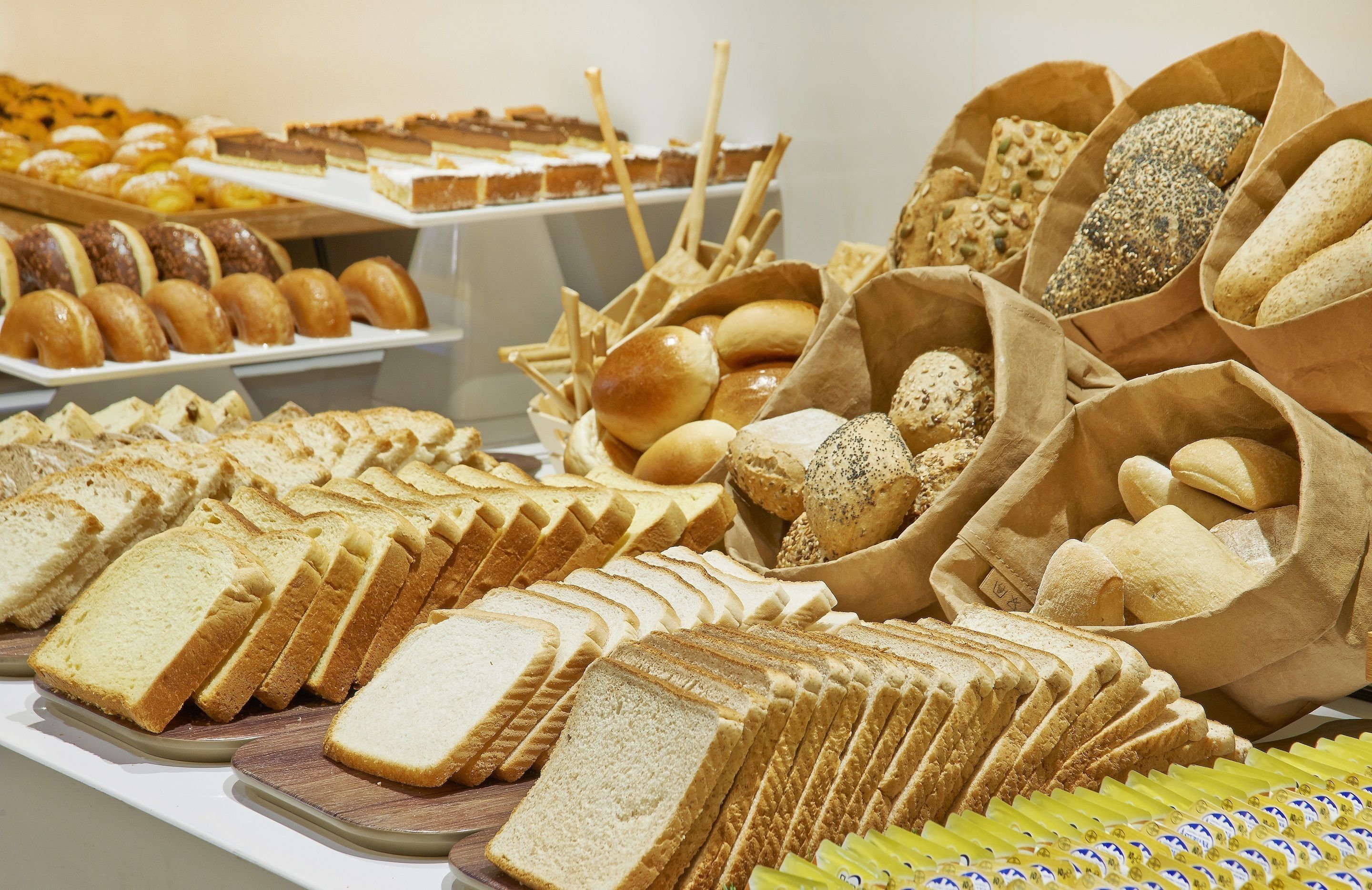 Variedad de panes y pasteles expuestos en un mostrador.