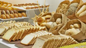Variedad de panes y pasteles expuestos en un mostrador.
