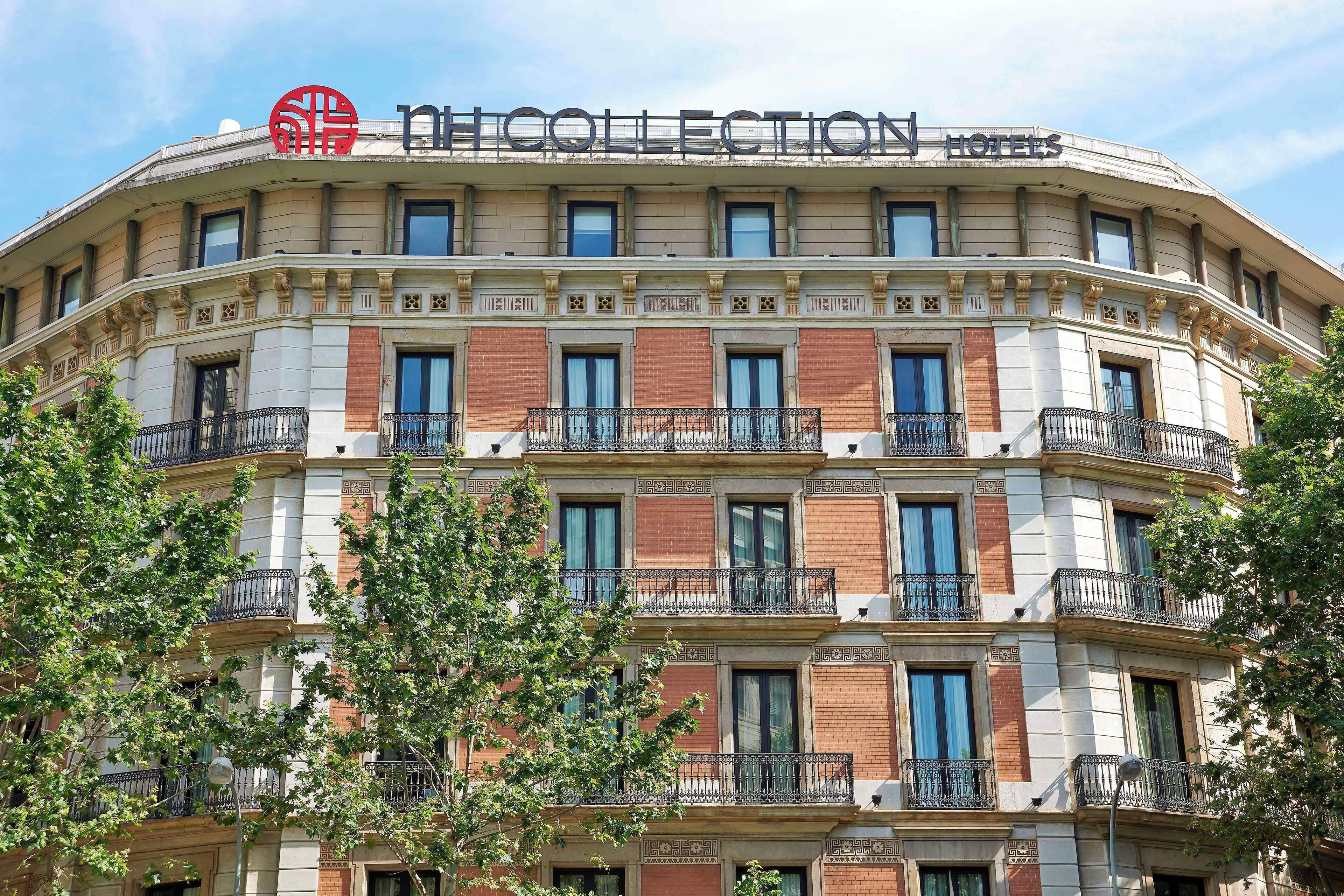 A multi-story hotel with balconies, a prominent logo, and a classic architectural design.