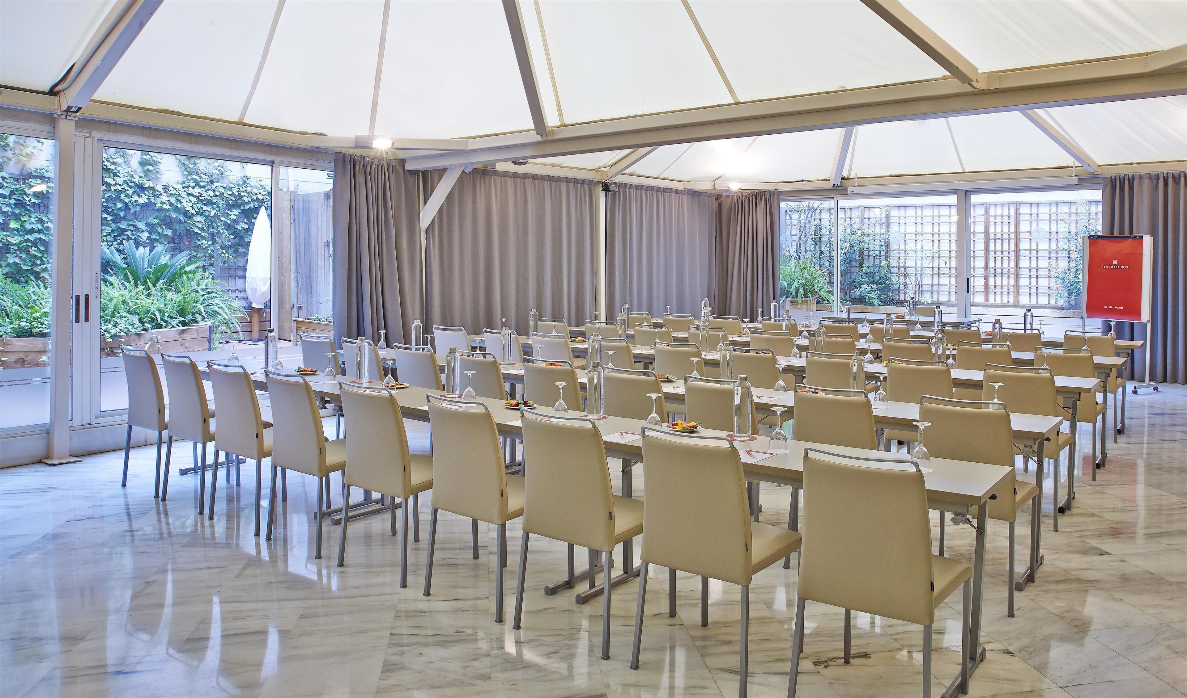 Un salón de conferencias con mesas y sillas dispuestas para una reunión.