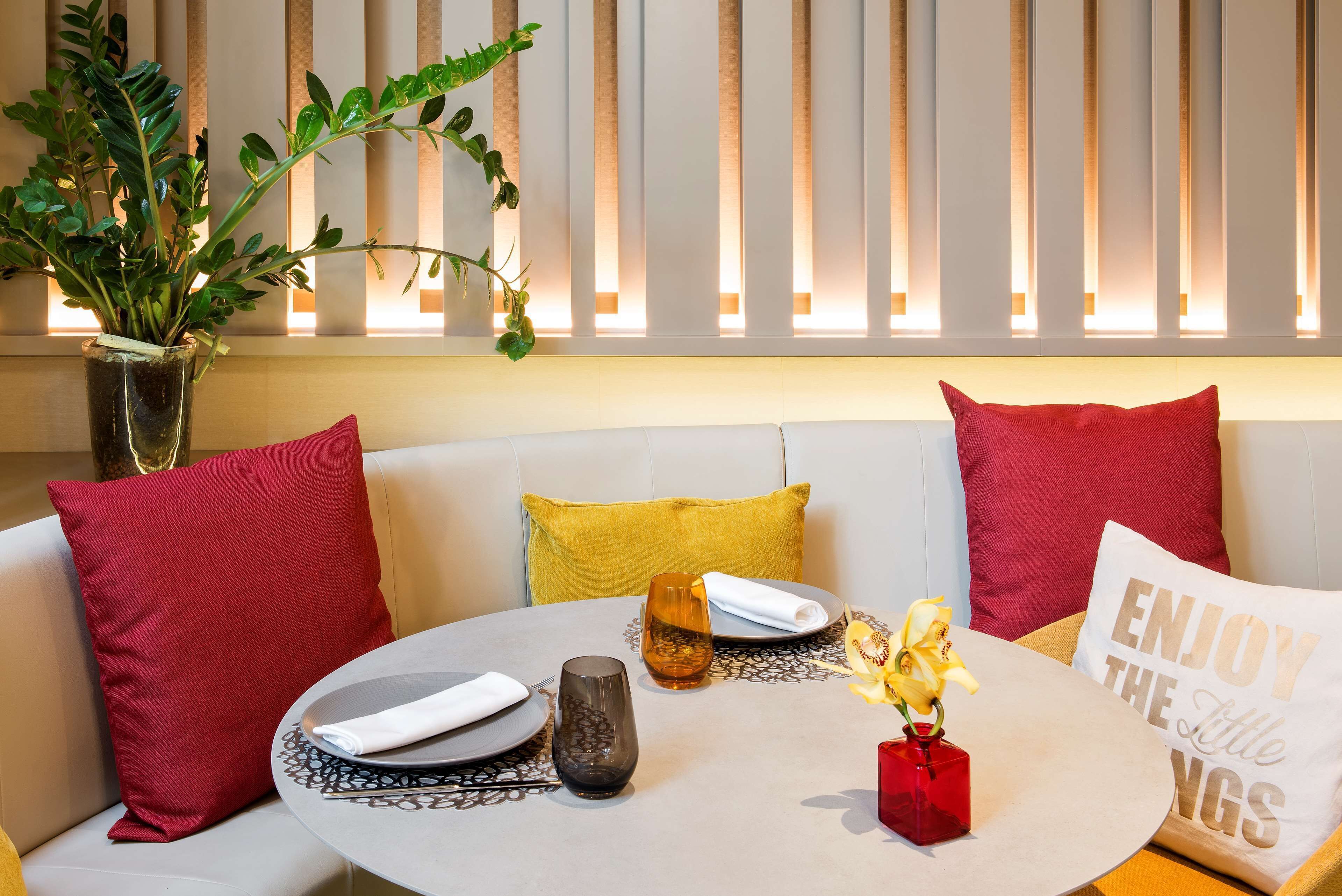 A modern living room with a sofa, a round table, and decorative pillows.