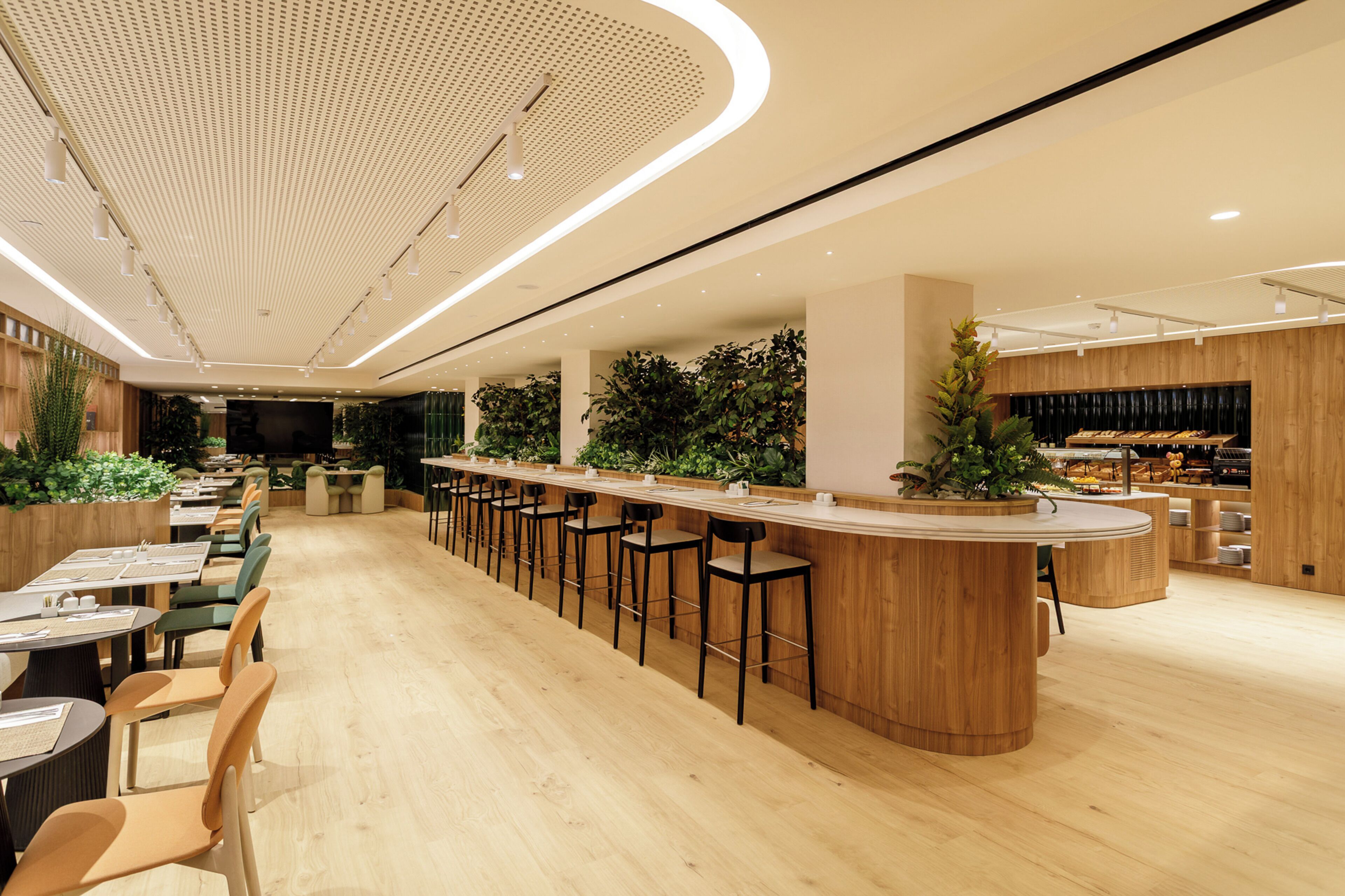 Un espace bar moderne avec un plancher en bois, des tabourets de bar et un long comptoir.