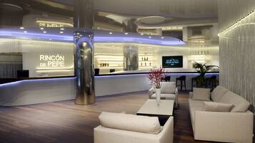 A modern hotel lobby with a reception desk, seating area, and a large pillar.