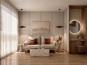 Ein stilvolles Wohnzimmer mit Sofa, Couchtisch, Pendelleuchten und einem Wandspiegel.