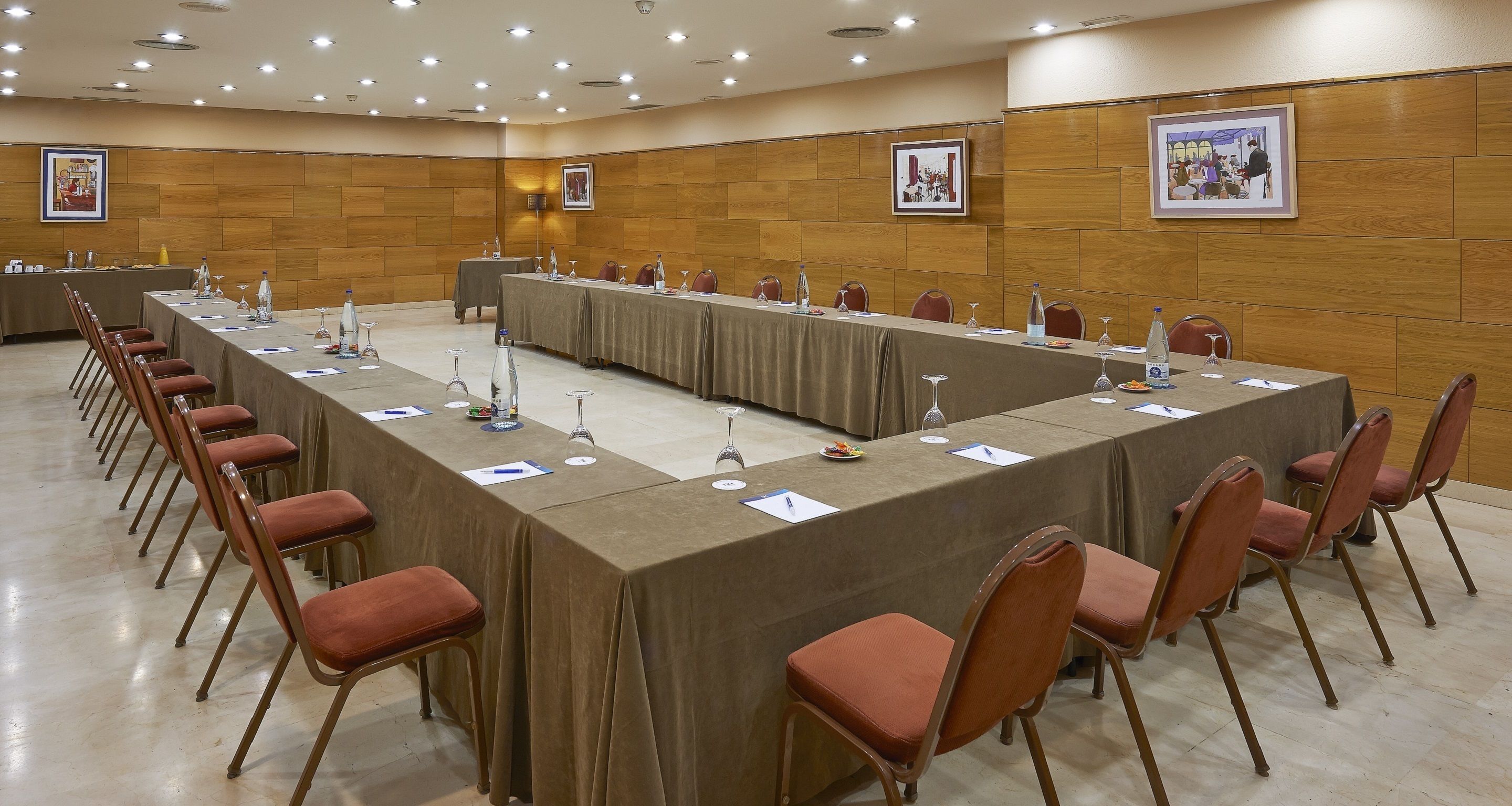 Uma sala de conferências com uma mesa comprida, cadeiras e placas de identificação.